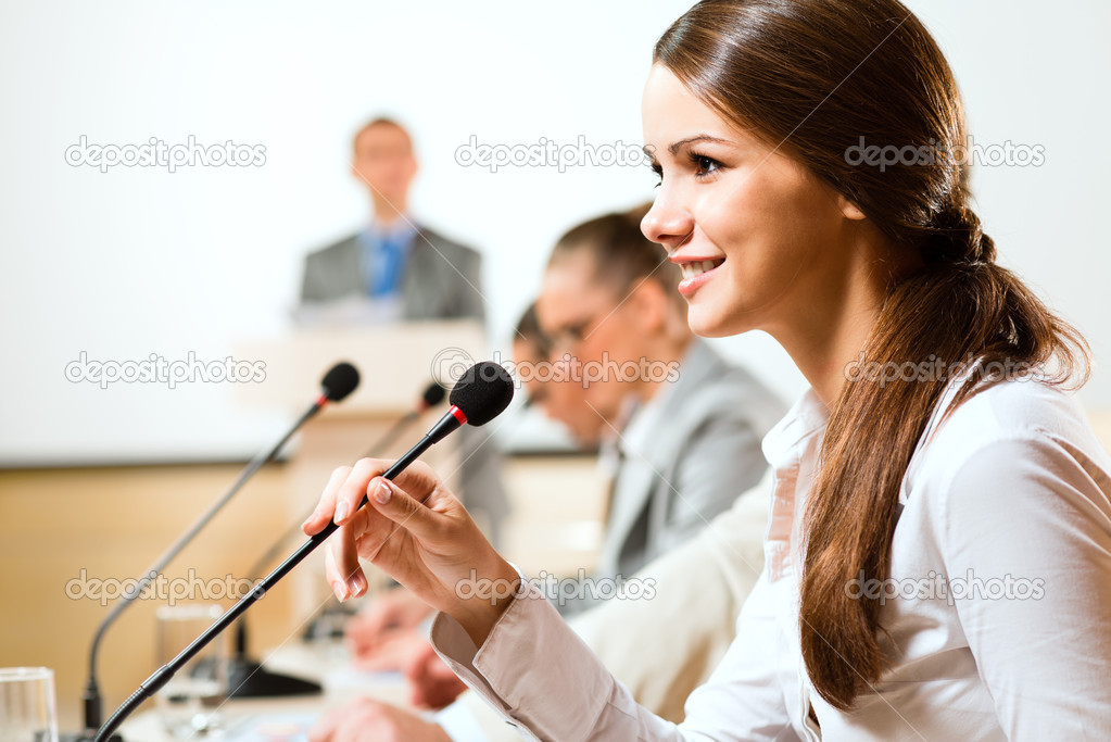 Business woman speaks into a microphone
