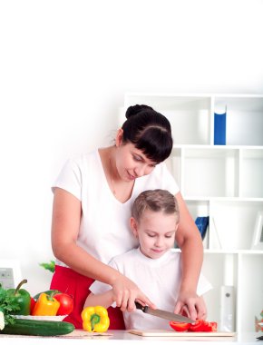 Anne ve kızı birlikte yemek pişiriyor.