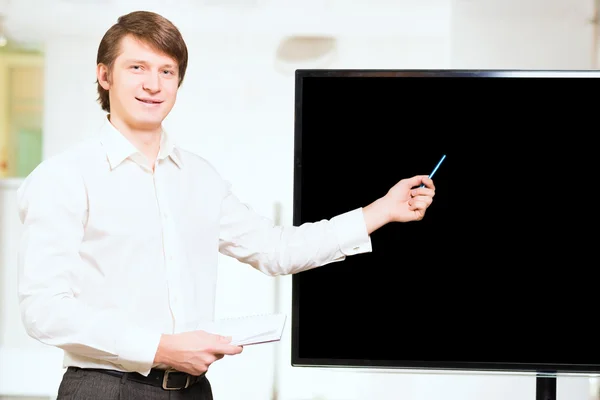 Uomo d'affari vestito informalmente mostra schermo bianco — Foto Stock