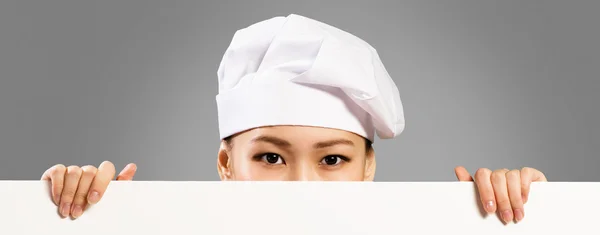 Asiatiska kvinnliga kock håller affisch för texten — Stockfoto