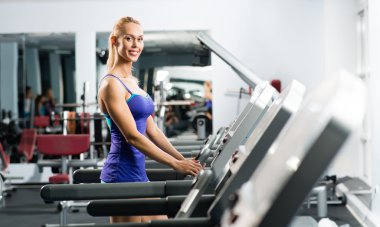 çekici bir genç kadın bir koşu bandı üzerinde çalışan