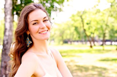 Portrait of an attractive woman in the park clipart