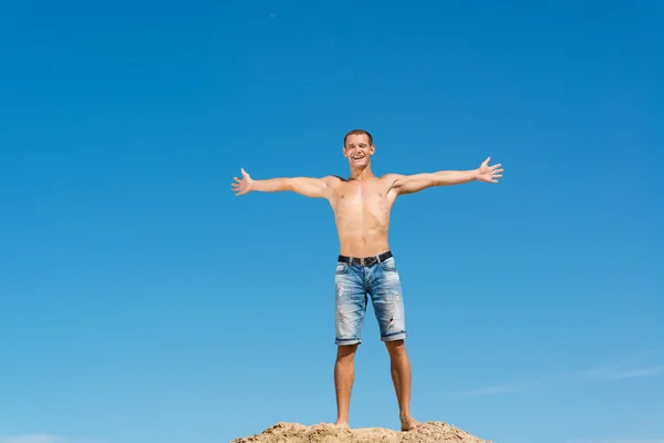 Uomo senza camicia contro cielo blu — Foto Stock