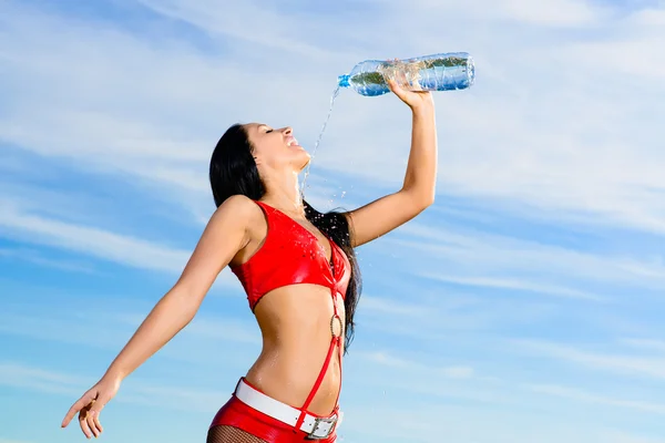 Ragazza sportiva in uniforme rossa con una bottiglia d'acqua — Foto Stock