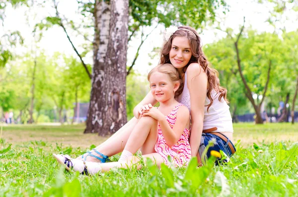 Mutter und Tochter sitzen zusammen im Gras — Stockfoto