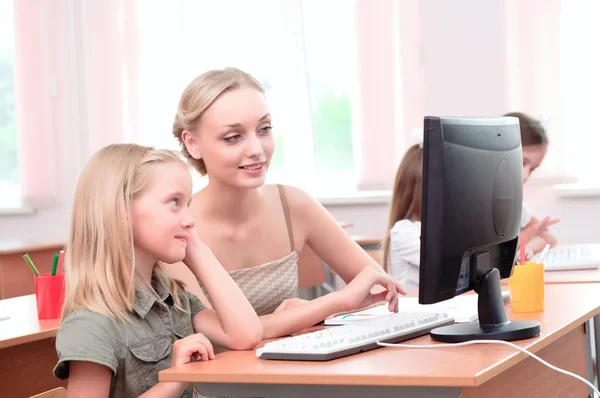 Leraar verklaart de taak schoolmeisje — Stockfoto