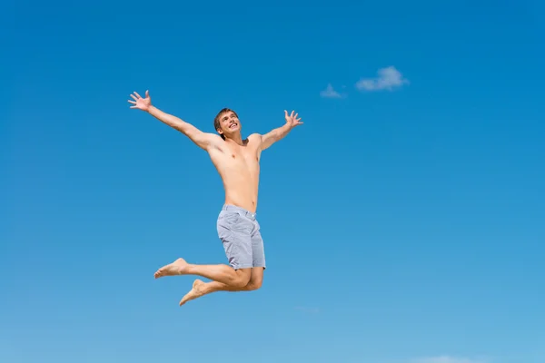 Shirtless man tegen blauwe hemel — Stockfoto