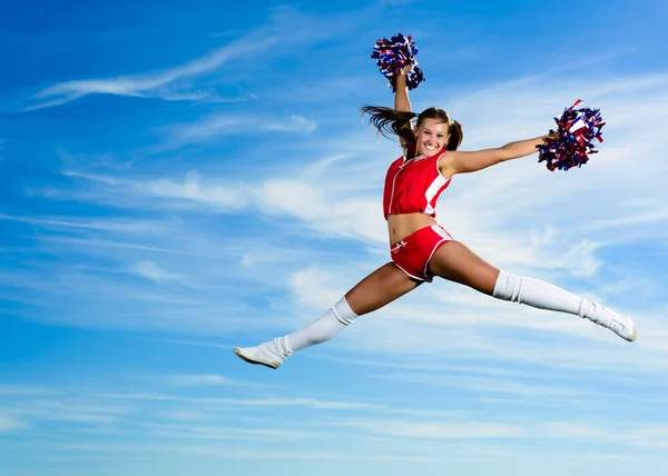 Jovem cheerleader em vermelho traje saltando — Fotografia de Stock