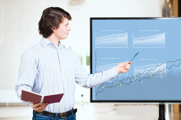 Jungunternehmer zeigt auf dem Monitor Charts — Stockfoto