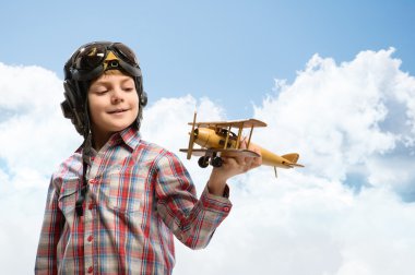 kask ile bir oyuncak uçak pilot oynayan çocuk