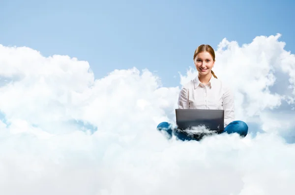 Jong meisje wordt uitgevoerd in de wolken met een laptop — Stockfoto