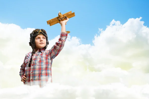 Boy in helmet pilot playing with a toy airplane — Stock Photo, Image