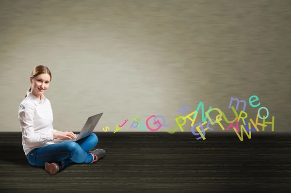 Jeune fille assise sur le sol avec un ordinateur portable — Photo