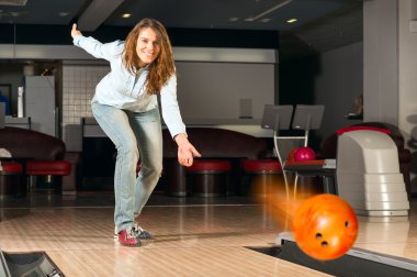 hoş genç bir kadın bir bowling topu atar