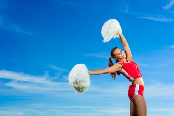 Młoda cheerleaderka w czerwony strój z pampon — Zdjęcie stockowe