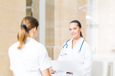 iki doktor hastane lobisinde konuşuyor