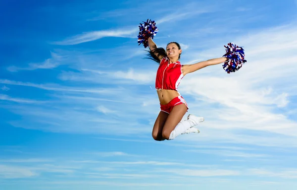 Ung cheerleader i röd dräkt hoppning — Stockfoto