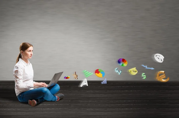 Young girl sitting on the floor with a laptop — Stock Photo, Image