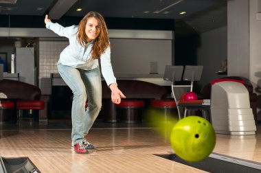 hoş genç bir kadın bir bowling topu atar