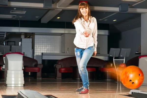 Hoş genç bir kadın bir bowling topu atar — Stok fotoğraf