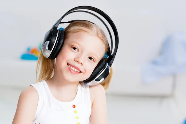 Menina bonita ouvindo música em fones de ouvido — Fotografia de Stock