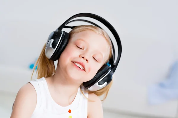 Menina bonita ouvindo música em fones de ouvido — Fotografia de Stock