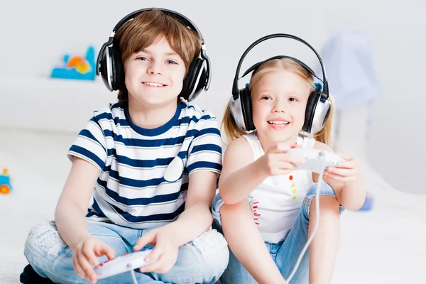 Cute boy and girl playing gaming console — Stock Photo, Image