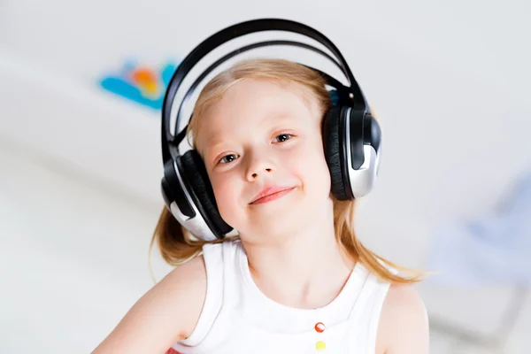 Menina bonita ouvindo música em fones de ouvido — Fotografia de Stock