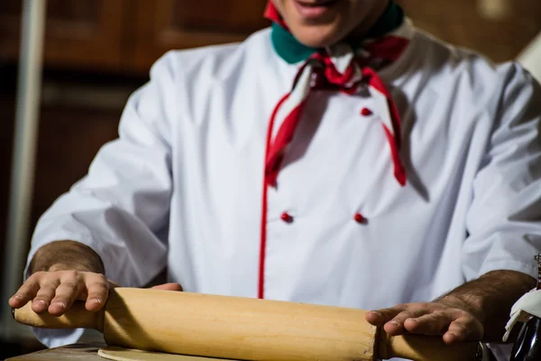 Cocinar despliega la masa en una tabla — Foto de Stock