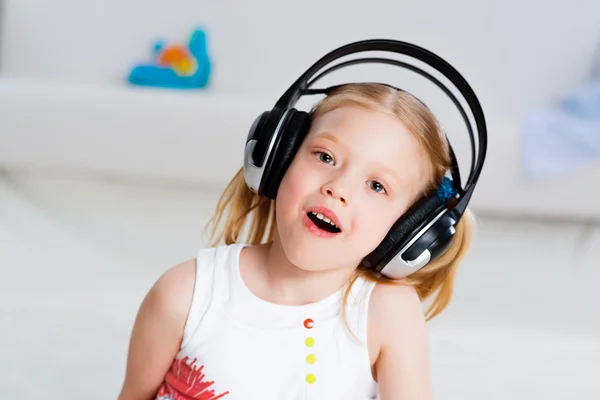 Pretty girl listening to music on headphones — Stock Photo, Image