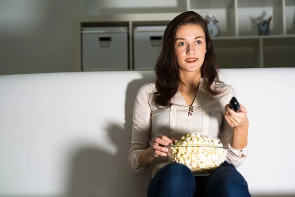 Ung kvinna tittar på TV — Stockfoto