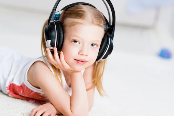 Menina bonita ouvindo música em fones de ouvido — Fotografia de Stock