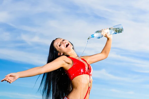 Sportmädchen in roter Uniform mit einer Flasche Wasser — Stockfoto