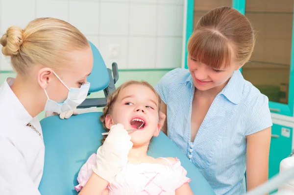 Dentistas do sexo feminino examina uma criança — Fotografia de Stock