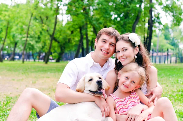 Gelukkige jonge familie met labrador — Stockfoto