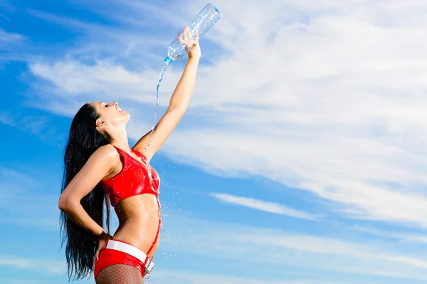 Sport fille en uniforme rouge avec une bouteille d'eau — Photo