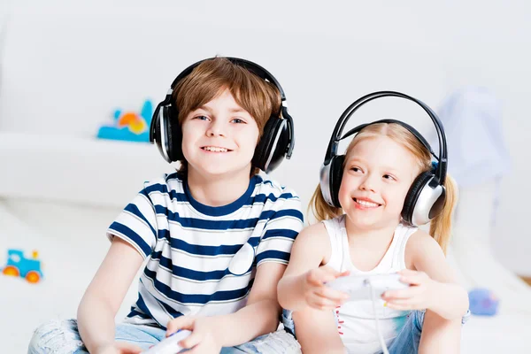 Menino bonito e menina jogando console de jogos — Fotografia de Stock