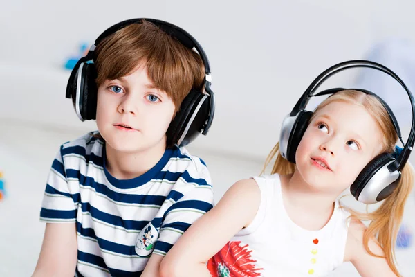 Brother and sister listening music with headphones — Stock Photo, Image