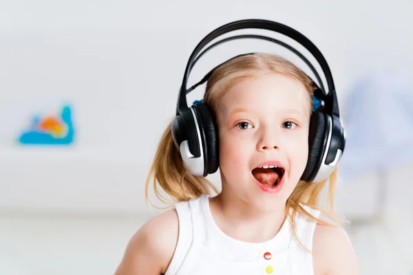 Menina bonita ouvindo música em fones de ouvido — Fotografia de Stock