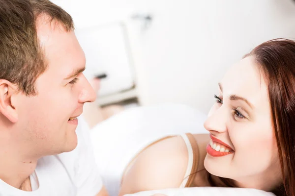 Jeune homme et femme couchés ensemble au lit — Photo