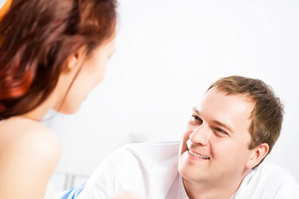 Jonge man liggend in bed met zijn vriendin — Stockfoto