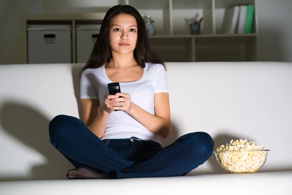 Молода жінка дивиться телевізор — стокове фото