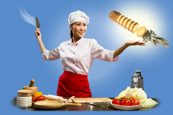 Asian female chef cuts pineapple — Stock Photo, Image