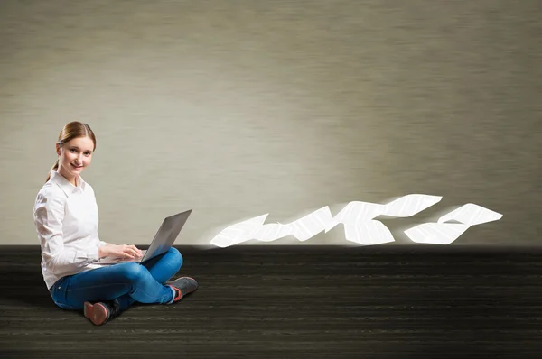 Jovem sentada no chão com um laptop — Fotografia de Stock