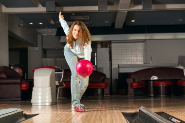 hoş genç bir kadın bir bowling topu atar