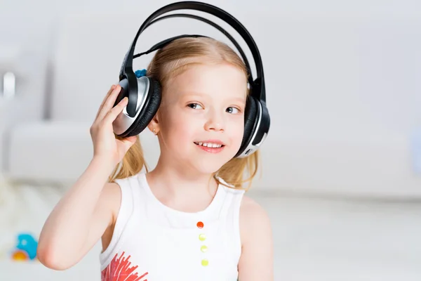 Menina bonita ouvindo música em fones de ouvido — Fotografia de Stock