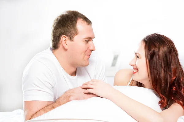 Young man and woman lying together in bed — Stock Photo, Image