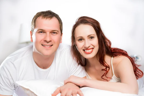 Jeune homme et femme couchés ensemble au lit — Photo