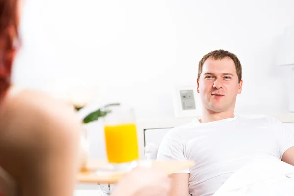 Woman brought her boyfriend breakfast in bed — Stock Photo, Image