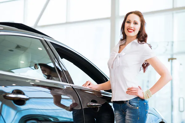 Joven mujer de pie cerca de un coche — Foto de Stock